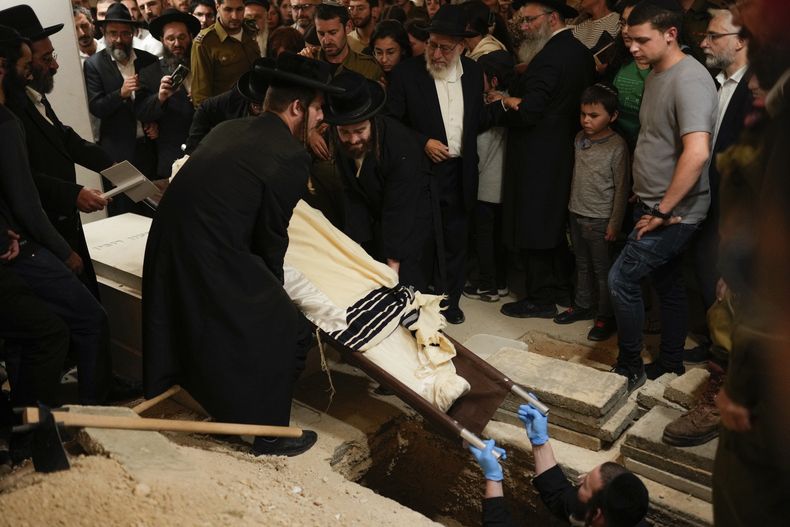 Dolientes se reúnen mientras es enterrado el cuerpo del soldado israelí Benjamin Loeb, quien también tenía nacionalidad francesa, durante su funeral, el martes 10 de octubre de 2023, en Jerusalén. Loeb murió el sábado después de que combatientes de Hamas en la Franja de Gaza llevaron a cabo una incursión sin precedentes en distintos puntos de Israel. (AP Foto/Francisco Seco)