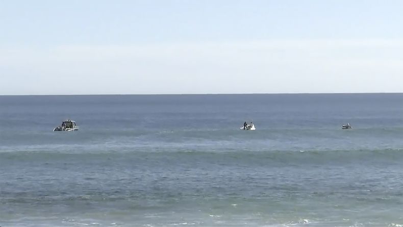 En esta imagen tomada de un video, equipos de búsqueda en botes trabajan en el mar en Elliston, Australia, el sábado 13 de mayo de 2023. La policía seguía buscando el lunes los restos de un surfista de 46 años atacado por un tiburón dos días antes ante la costa de Australia. (Australian Broadcasting Corp. via AP)