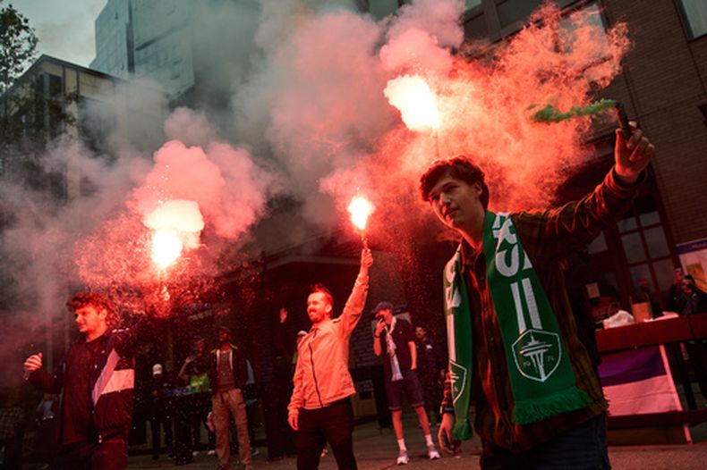 Los aficionados encienden bengalas mientras los seguidores de los Sounders de Seattle marchan antes de un partido de fútbol de la MLS contra los Timbers de Portland, el jueves 16 de julio de 2026, en Seattle. (Foto AP/Lindsey Wasson)