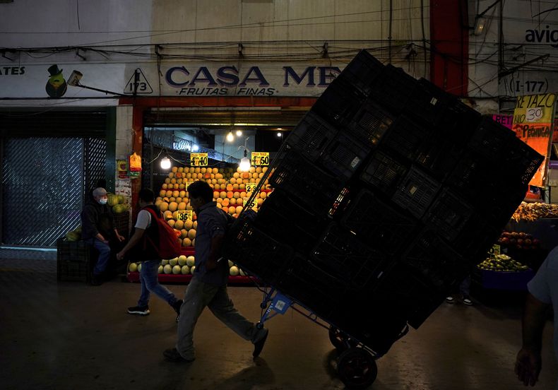 ARCHIVO - Un porteador traslada cajas de mercadería en la Central de Abastos, el mercado más grande y más completo de alimentos y bienes, en Ciudad de México, el 3 de agosto de 2022. Los presidentes de 11 países de Latinoamérica y el Caribe se comprometieron el 5 de abril de 2023, en una reunión virtual, a facilitar el intercambio comercial de alimentos para abatir la inflación. La segunda cita, prevista para mayo, fue pospuesta por México el martes 25 de abril de 2023, aludiendo al contagio de López Obrador de coronavirus por tercera vez. (AP Foto/Fernando Llano, Archivo)