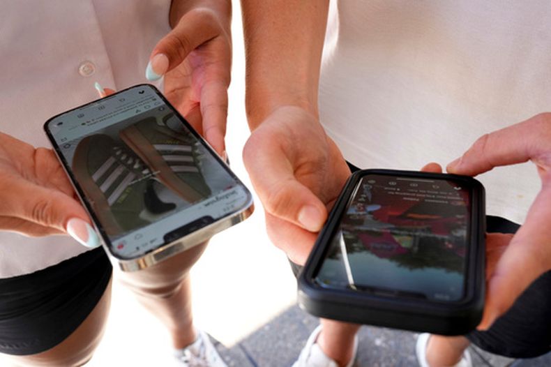 ARCHIVO – Varios jóvenes usan sus teléfonos celulares para mirar redes sociales en Sydney, el 8 de noviembre de 2024. (AP Foto/Rick Rycroft, Archivo