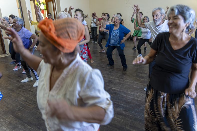 Maylo Pajón Lorenzo (centro) baila con amigos y amigas en una clase para adultos mayores en el estudio Lizt Alfonso Dance Cuba, en La Habana, el martes 4 de febrero de 2025. (Foto AP/Ramón Espinosa)