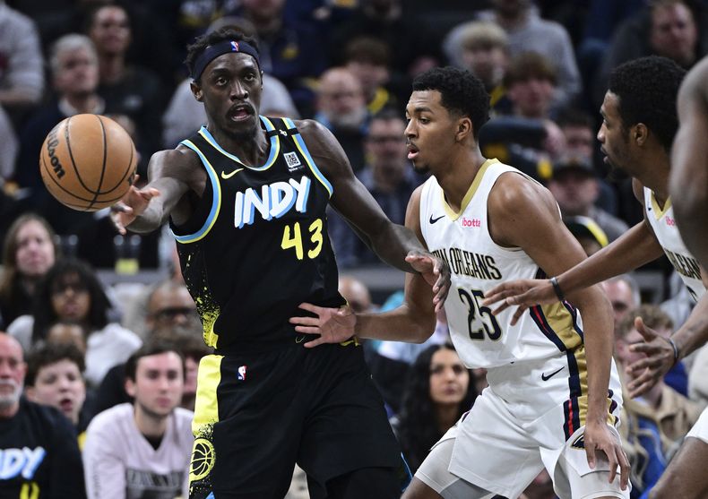Pascal Siakam, alero de los Pacers de Indiana, envía un pase frente a Trey Murphy III, base de los Pelicans de Nueva Orleáns, el miércoles 28 de febrero de 2024 (AP Foto/Marc Lebryk)