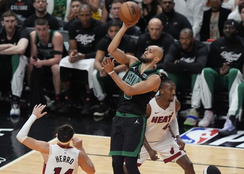 El escolta de los Celtics de Boston, Derrick White (9), anota sobre el escolta del Heat de Miami, Tyler Herro (14), durante la primera mitad del Juego 4 de un partido de primera ronda de baloncesto de la NBA, el lunes 29 de abril de 2024, en Miami. (AP Foto/Marta Lavandier)