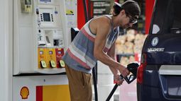 ARCHIVO - Patrick Coffin, residente en Oregón, llena el tanque de su coche en una gasolinera de Portland, Oregón, el 4 de agosto de 2023. (AP Fo/Claire Rush, Archivo)