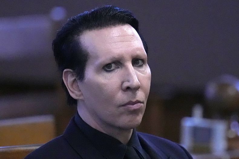 Marilyn Manson, cuyo nombre verdadero es Brian Hugh Warner, espera al juez en la Corte Superior de Belknap Superior Court el lunes 18 de septiembre de 2023, en Laconia, Nueva Hampshire. Marilyn Manson fue sentenciado a 20 horas de servicio comunitario y una multa el lunes por sonarse la nariz sobre una camarógrafa en un concierto de 2019 en Nueva Hampshire. (Foto AP/Charles Krupa)