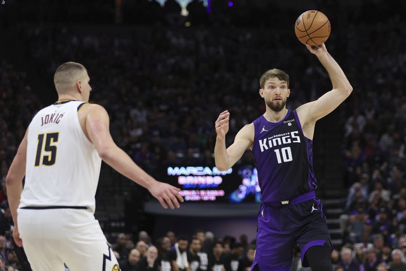 El lituano Domantas Sabonis, alero de los Kings de Sacramento, envía un pase frente al serbio Nikola Jokic, pívot de los Nuggets de Denver, el viernes 9 de febrero de 2024 (AP Foto/Jed Jacobsohn)