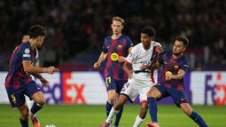 Senny Mayulu empujado por jugadores del Barcelona en el encuentro de la Liga de Campeones el miércoles primero de octubre del 2025. (AP Foto/Emilio Morenatti)