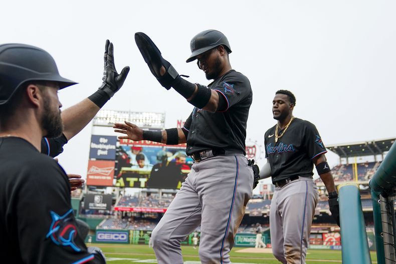 Luis Arraez y Jorge Soler de los Marlins de Miami regresan al dugout tras anotar en la primera entrada del encuentro ante los Nacionales de Washington el viernes 16 de junio del 2023. (AP Foto/Alex Brandon)