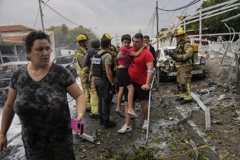 Israelíes evacuan una zona alcanzada por un proyectil disparado desde la Franja de Gaza, en Ashkelon, en el sur de Israel, el 9 de octubre de 2023. (AP Foto/Ohad Zwigenberg)
