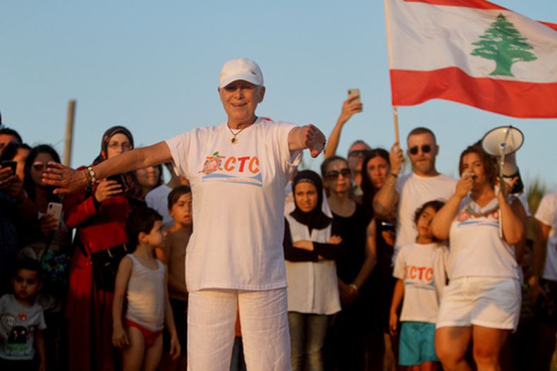 Mona Khalil, una conservacionista libanesa que murió el viernes tras resultar herida en un ataque israelí a su casa en la costa sur del Líbano, festeja la liberación de crías de tortugas marinas durante un evento en la aldea de Mansouri, cerca de la ciudad de Tiro, en el sur del Líbano, el 31 de julio de 2019. (Foto AP/Hussein Malla)