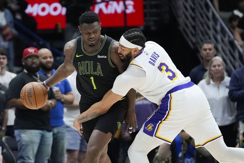 El alero de los Pelicans de Nueva Orleans, Zion Williamson (1), conduce el balón contra el alero de los Lakers de Los Ángeles, Anthony Davis (3), en la primera mitad de un partido de baloncesto de la NBA en Nueva Orleans, el domingo 14 de abril de 2024. (AP Foto/Gerald Herbert)