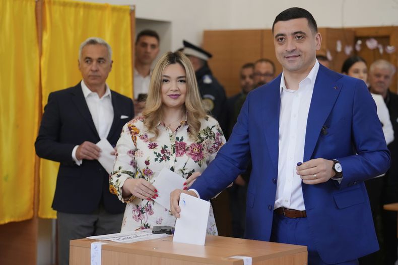 El candidato presidencial George Simion vota junto a su esposa, Ilinca, en la segunda ronda de las elecciones presidenciales repetidas, en Mogosoaia, Rumanía, el domingo 18 de mayo de 2025. (AP Foto/Vadim Ghirda)