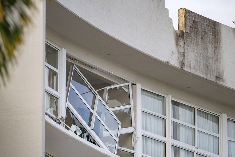 Una ventana rota se ve colgando en el hotel Double Tree by Hilton de Cairns, Australia, después de que un helicóptero se estrellara en su tejado la madrugada del lunes 12 de agosto de 2024. (Brian Cassey/AAP Image via AP)