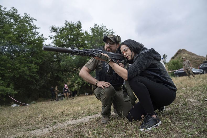 Una mujer dispara un AK-47 durante un entrenamiento táctico para civiles cerca de Zaporiyia, Ucrania, el domingo 9 de julio de 2023. (AP Foto/Evgeniy Maloletka)