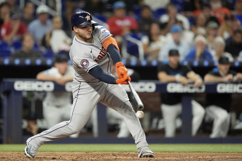 El receptor Yainer Diaz, de los Astros de Houston, conecta un doblete que produce carreras de Christian Walker y Victor Caratini, en la cuarta entrada del juego de béisbol de Grandes Ligas frente a los Marlins de Miami, el lunes 4 de agosto de 2025, en Miami. (AP Foto/Rebecca Blackwell)