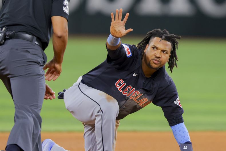 El dominicano de los Guardianes de Cleveland José Ramírez hace una seña hacia el árbitro luego de robar la segunda base en la séptima entrada del juego de béisbol ante los Rangers de Texas, el lunes 13 de mayo de 2024, en Arlington, Texas. (AP Foto/Gareth Patterson)