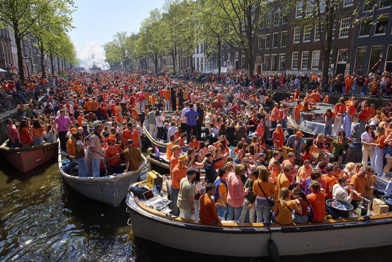 El canal de Herengrscht, atestado de botes mientras las personas celebran el Día del Rey en Ámsterdam, Holanda, el sábado 26 de abril de 2025. (AP Foto/Peter Dejong)