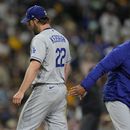 Dave Roberts, derecha, manager de los Dodgers de Los Ángeles, recibe la pelota de manos del lanzador Clayton Kershaw, izquierda, mientras éste sale del partido durante la quinta entrada, el viernes 5 de mayo de 2023, en San Diego. (AP Foto/Gregory Bull)