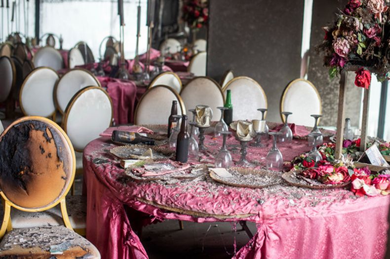 Decoraciones de mesa cubiertas de ceniza y escombros tras un incendio en un edificio donde se realizaba una fiesta de boda en Lingwala, República Democrática del Congo, el sábado 5 de septiembre de 2026. (AP Foto/Guylain Kipoke)