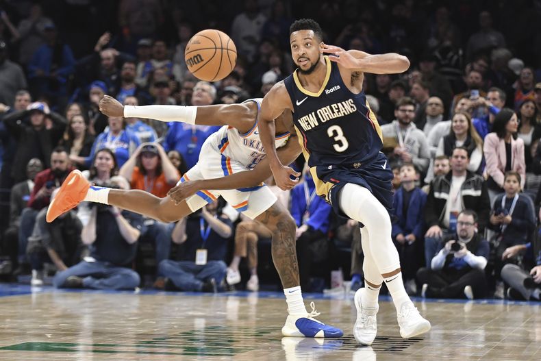 CJ McCollum, de los Pelicans de Nueva Orleáns, persigue un balón delante de Jalen Williams, del Thunder de Oklahoma City, en el encuentro del miércoles 1 de noviembre de 2023 (AP Foto/Kyle Phillips)
