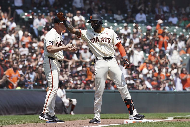 Derek Hill, de los Gigantes de San Francisco, a la derecha, celebra después de conectar un triple contra los Rockies de Colorado durante la segunda entrada en San Francisco, el domingo 28 de julio de 2024. (AP Foto/Kavin Mistry)
