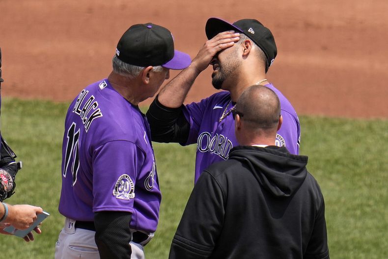El abridor de los Rockies de Colorado Antonio Senzatela, arriba a la derecha, es visitado en el montículo por el mánager Bud Black (10) y un médico después de permitir un cuadrangular de dos carreras a Andrew McCutchen, de los Piratas de Pittsburgh, durante la tercera entrada del juego de béisbol en Pittsburgh, el miércoles 10 de mayo de 2023. Black decidió retirarlo del partido y Senzatela salió con el médico. (AP Foto/Gene J. Puskar)