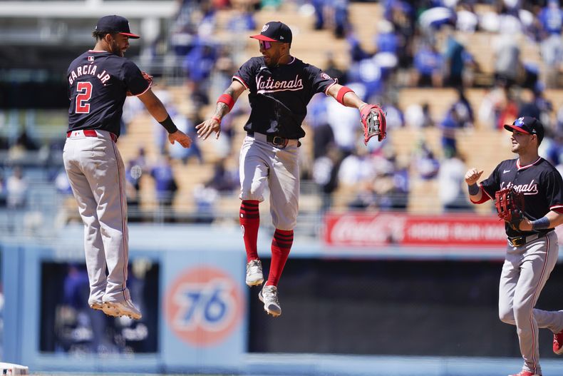 Luis García Jr. (izquierda), de los Nacionales de Washington, festeja con su compañero, el boricua Eddie Rosario (centro) y con el jardinero derecho Lane Thomas, tras el triunfo sobre los Dodgers de Los Ángeles, el miércoles 17 de abril de 2024 (AP Foto/Ryan Sun)