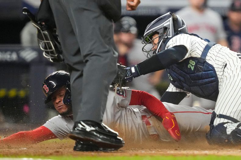 Ceddanne Rafaela, de los Medias Rojas de Boston, es retirado por el catcher Austin Wells, de los Yankees de Nueva York, durante el encuentro del viernes 28 de agosto de 2026 (AP Foto/Yuki Iwamura)