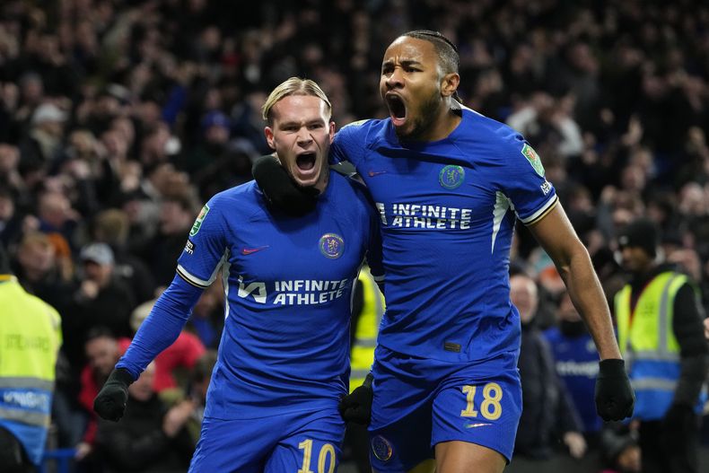 Mykhailo Mudryk (izquierda), del Chelsea, festeja con su compañero Christopher Nkunku, luego de anotar en los cuartos de final de la Copa de la Liga inglesa ante Newcastle el martes 19 de diciembre de 2023 (AP Foto/Kirsty Wigglesworth)