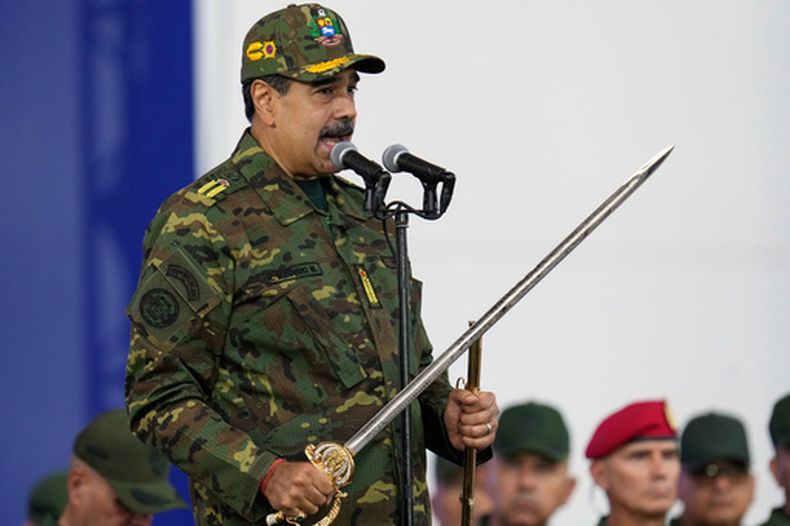 El presidente de Venezuela, Nicolás Maduro, sostiene una espada ceremonial que se dice que perteneció al héroe independentista Simón Bolívar durante una marcha cívico-militar organizada por el gobierno en Caracas, Venezuela, el 25 de noviembre de 2025. (AP Foto/Ariana Cubillos)