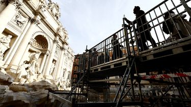 Personas caminan por una pasarela elevada que da acceso limitado a la Fuente de Trevi durante trabajos de mantenimiento en Roma, el sábado 9 de noviembre de 2024. (Cecilia Fabiano/LaPresse vía AP)