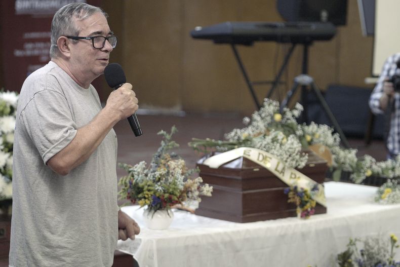 Rodrigo Londoño, líder máximo de la guerrilla desmovilizada de las Fuerzas Armadas Revolucionarias de Colombia (FARC), en su intervención en un acto para recordar a José de La Paz Vanegas, guerrillero conocido como Cristian Pérez que desapareció y cuyos restos fueron luego localizados, colocados en el pequeño ataúd de detrás, en Cali, Colombia, el jueves 31 de octubre de 2024. (AP Foto/Juan Bautista Díaz)