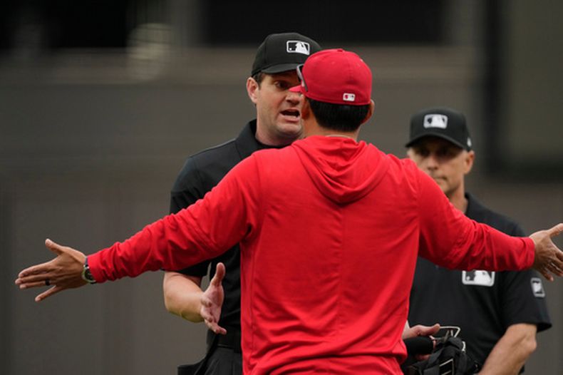 Kurt Suzuki, manager de los Angelinos de Los Ángeles, discute con el umpire del plato ADam Beck durante el juego del sábado 11 de abril de 2026 ante los Rojos de Cincinnati (AP Photo/Carolyn Kaster)