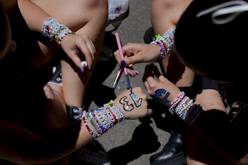 Fans de Taylor Swift se pintan las manos con el número 13 mientras esperan a que abran las puertas del estadio Monumental para el primer concierto de la gira Eras en Buenos Aires, Argentina, el jueves 9 de noviembre de 2023. (Foto AP/Natacha Pisarenko)
