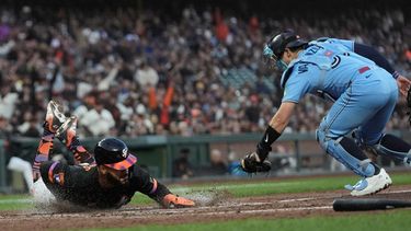 Heliot Ramos (izquierda), de los Gigantes de San Francisco, se desliza en el plato para anotar contra el receptor de los Azulejos de Toronto, Brandon Valenzuela, durante la quinta entrada de un partido de béisbol, el martes 7 de julio de 2026, en San Francisco. (Foto AP/Jeff Chiu)