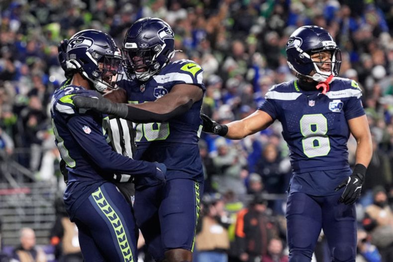 El cornerback de los Seahawks de Seattle, Devon Witherspoon, izquierda, celebra tras interceptar un pase en cuarta oportunidad durante la segunda mitad del Juego de Campeonato de la NFC contra los Rams de Los Ángeles, el domingo 25 de enero de 2026 en Seattle. (Foto AP/Godofredo A. Vásquez)