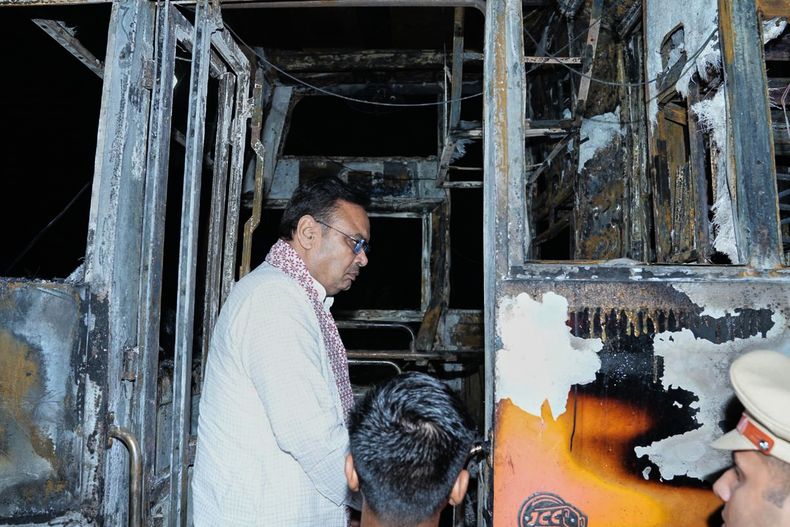 Esta imagen compartida por la oficina del ministro jefe del estado indio de Rajastán muestra al ministro jefe, Bhajan Lal Sharma, inspeccionando un autobús de pasajeros calcinado tras un posible cortocircuito que podría haber provocado un incendio letal cerca de Jaisalmer, India, el martes 14 de octubre de 2025. (Oficina del ministro jefe del estado indio de Rajastán via AP)