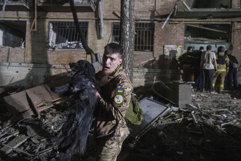 Un soldado ucraniano retira a un perro de una casa dañada por un ataque aéreo ruso en un vecindario residencial, el jueves 24 de abril de 2025, en Kiev, Ucrania. (AP Foto/Evgeniy Maloletka)