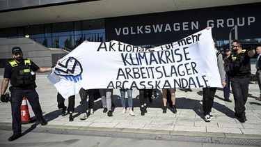 Manifestantes sostienen un letrero afuera del edificio de Volkswagen en Berlín, el miércoles 10 de mayo de 2023. (Britta Pedersen/dpa via AP)