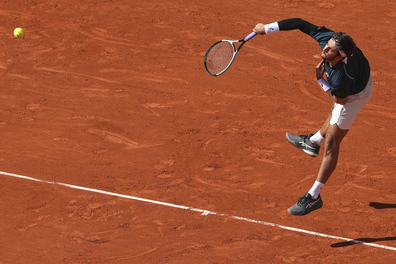 El italiano Lorenzo Musetti saca contra el alemán Yannick Hanfmann durante su partido de primera ronda del Abierto de Francia de tenis en el estadio Roland Garros, en París, el domingo 25 de mayo de 2025. (AP Foto/Lindsey Wasson)