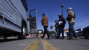 Agentes federales escoltan a un hombre a un autobús después de que fue detenido tras presentarse en un tribunal migratorio, el martes 22 de julio de 2025, en San Antonio. (AP Foto/Eric Gay)