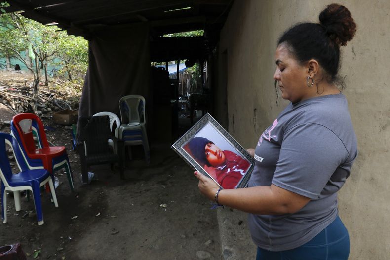 Norma Saraí Espinoza Maradiaga sostiene una fotografía de su hijo, Ángel Eduardo Maradiaga Espinoza, en su hogar en Olanchito, Honduras, el sábado 13 de mayo de 2023. Maradiaga, un migrante hondureño de 17 años, murió bajo custodia de las autoridades de inmigración de Estados Unidos en el centro de retención en Safety Harbor, Florida. (AP Foto/Delmer Martinez)