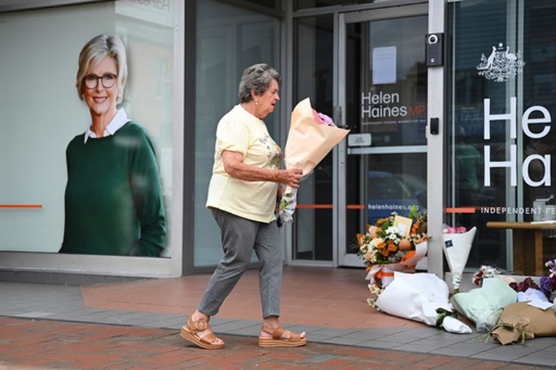 Una mujer lleva flores a la oficina electoral de la parlamentaria independiente Helen Haines, en Wangaratta, Australia, el martes 20 de octubre de 2026. (James Ross/AAP Image via AP)