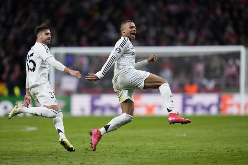 Kylian Mbappé y Raúl Asencio (izquierda) celebran la victoria del Real Madrid en una tanda de penales ante el Atlético de Madrid en los octavos de final de la Liga de Campeones, el 12 de marzo de 2025. (AP Fto/Manu Fernández)
