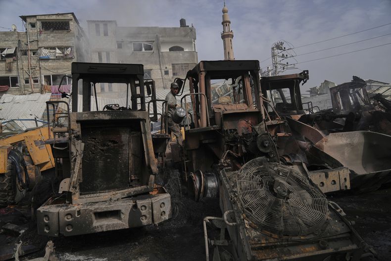 Palestinos examinan los restos de excavadoras alcanzadas por un ataque aéreo del ejército israelí en Jabaliya, en el norte de la Franja de Gaza, el 22 de abril de 2025. (AP Foto/Jehad Alshrafi)