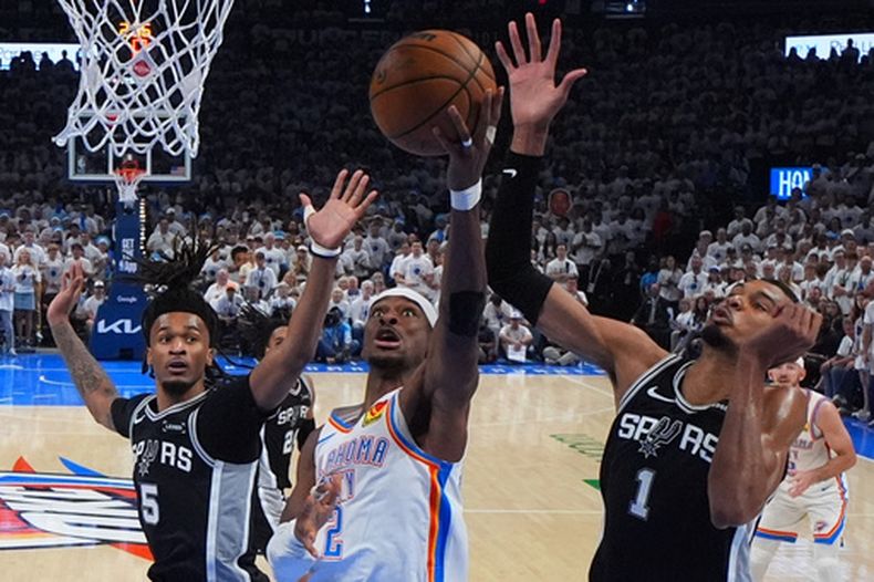 Shai Gilgeous-Alexander, del Thunder de Oklahoma City, dispara frente a Victor Wembanyama, de los Spurs de San Antonio, en el quinto partido de las finales de la Conferencia Oeste, el martes 26 de mayo de 2026 (AP Foto/Julio Cortez)