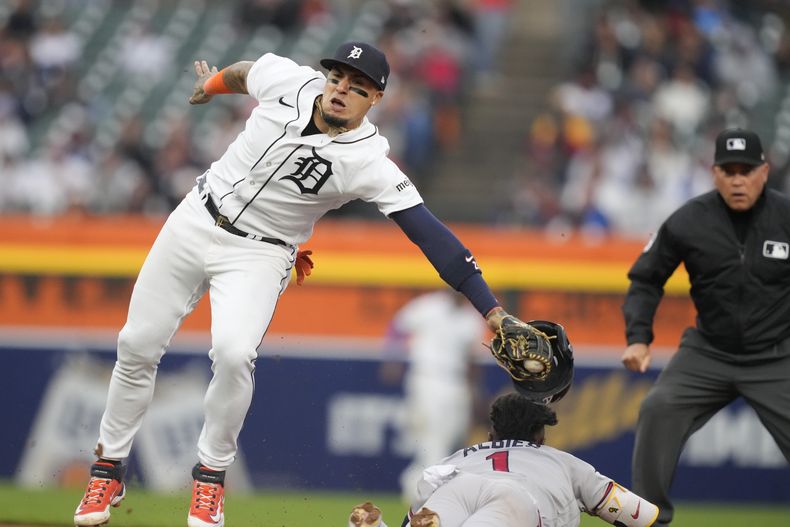 Ozzie Albies de los Bravos de Atlanta evita el tag del campocorto de los Tigres de Detroit Javier Baez y roba la base en la sexta entrada del juego del lunes 12 de junio del 2023. (AP Foto/Carlos Osorio)