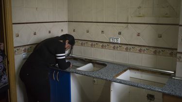 americateve | Carolina Salazar cubre su cara luego de que sus pertenencias han sido removidas de la casa de la cual fue expulsada en Madrid el jueves 27 de febrero de 2014. (Foto de AP/Andres Kudacki)