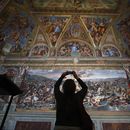 ARCHIVO - Un visitante admira una Sala de Rafael dentro de los Museos Vaticanos en el Vaticano, el 3 de mayo de 2021. (Foto AP/Alessandra Tarantino, archivo)
